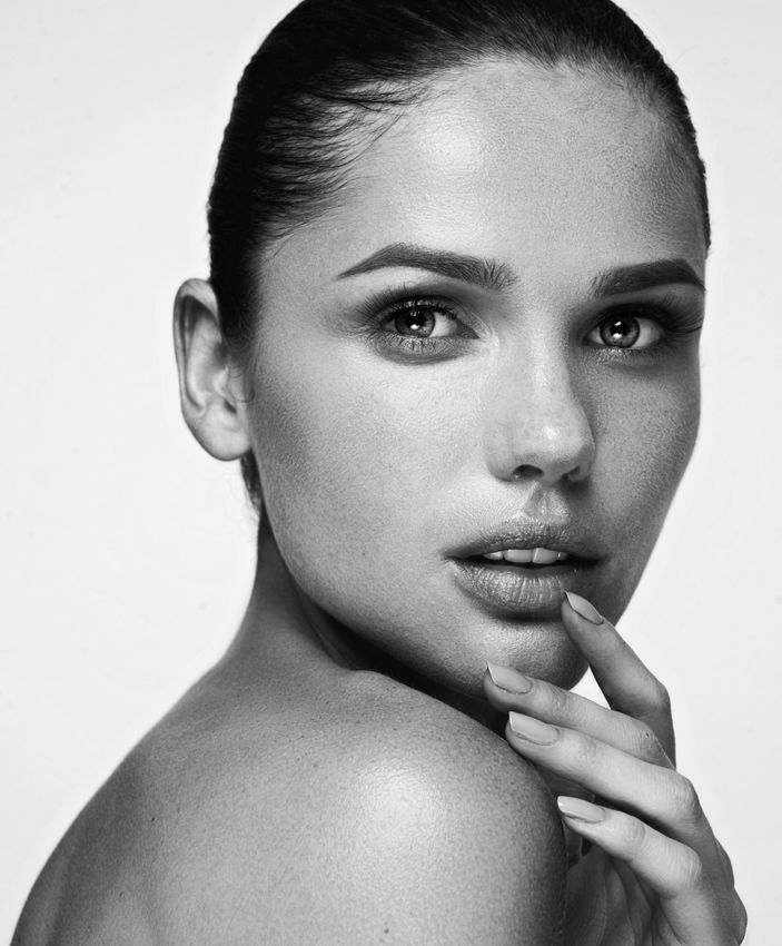 Thoughtful woman in black and white photo, chin resting on hand
